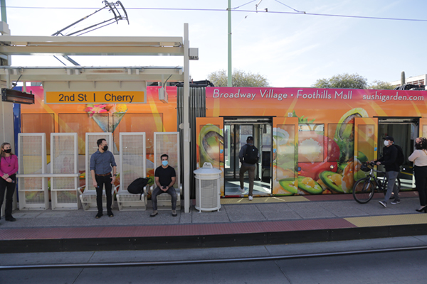 people waiting at a streetcar stop