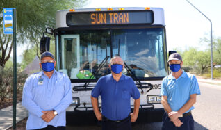 drivers standing in front of a bus