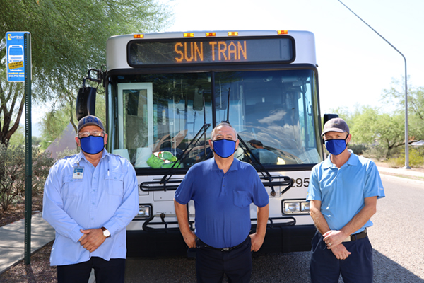 drivers standing in front of a bus