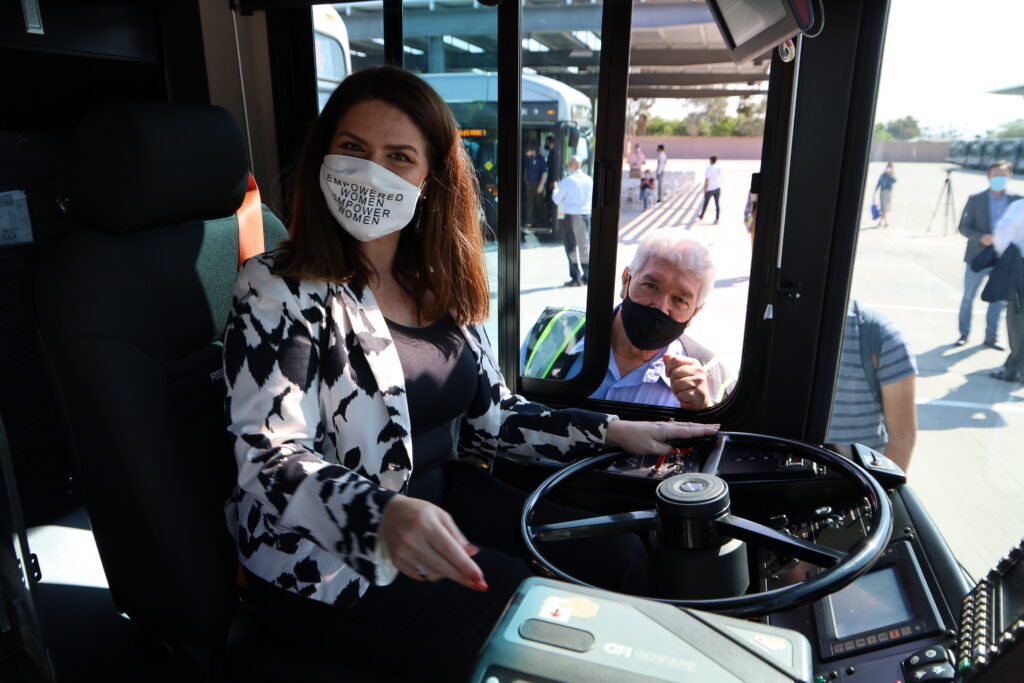 Sun Tran coach operator Joe shows City of Tucson Mayor Regina Romero how to start the electric bus.