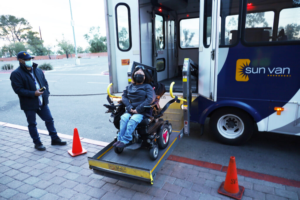 Sun Van driver David helps client Amanda Parkman exit the vehicle.