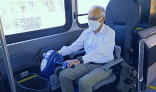 Rider in a power scooter uses Quantum device on a Sun Tran bus