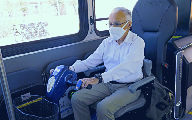 Rider in a power scooter uses Quantum device on a Sun Tran bus