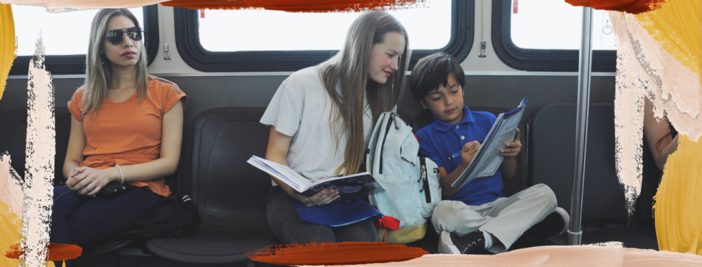 Two students do homework while riding on a Sun Tran bus.