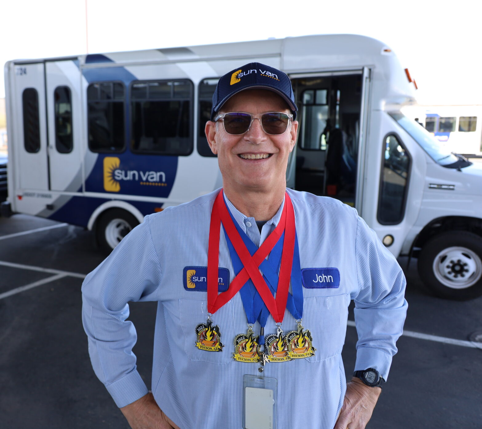 Sun Van driver John Spicker shows off his swimming medals.